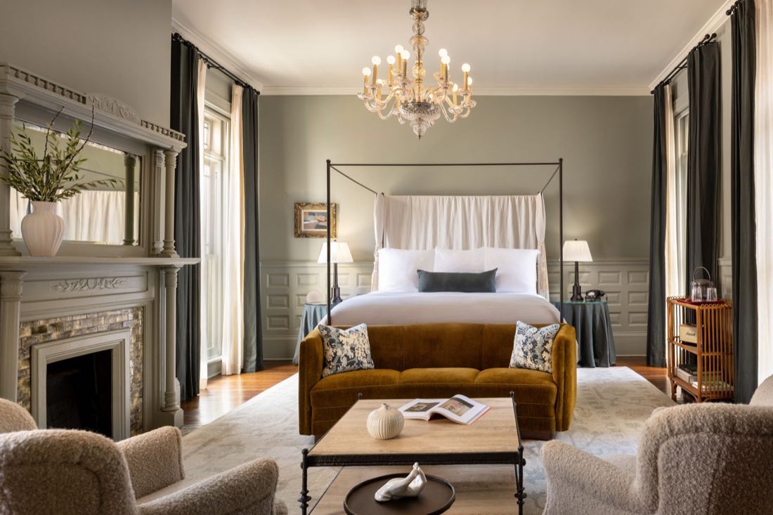 Room Five, the four-poster and rust velvet sofa beneath a crystal chandelier.