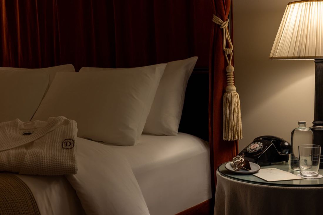 Room Eight at night, the bed turned down with a monogrammed waffle robe laid across it