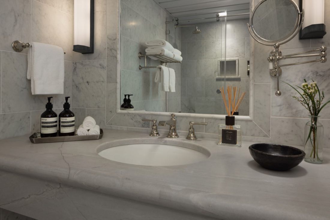 The bathroom in Room Nine, a marble vanity with a black stone bowl and a towel rack.
