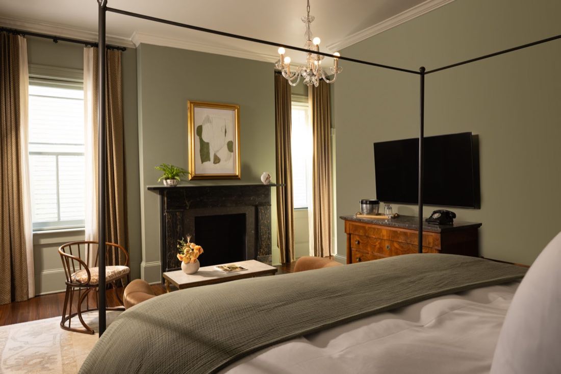 Room Nine, a four-poster against olive-green walls beside a black marble mantel.