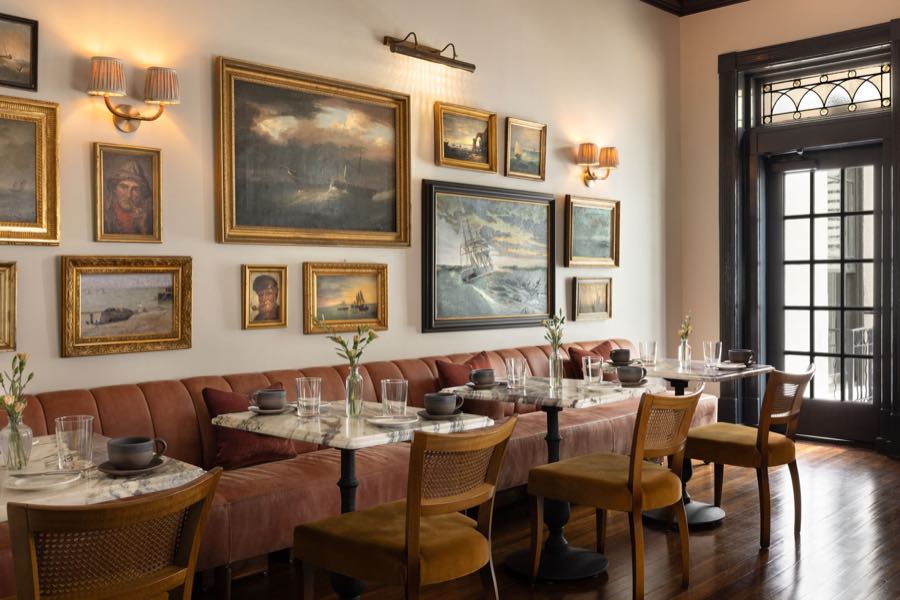 The breakfast room, blush banquette and salon-hung gilt paintings