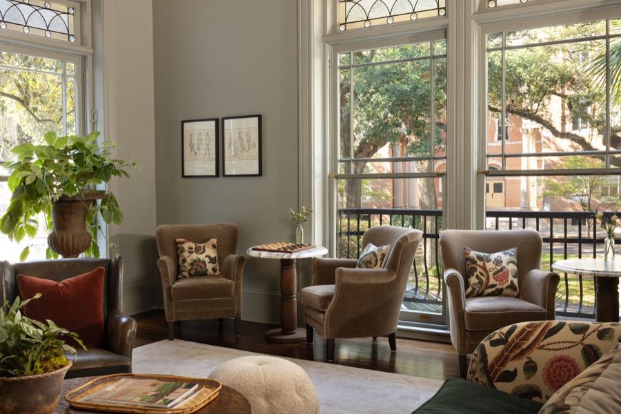 The Parlor, with arched windows onto the square and wing chairs drawn up to the light