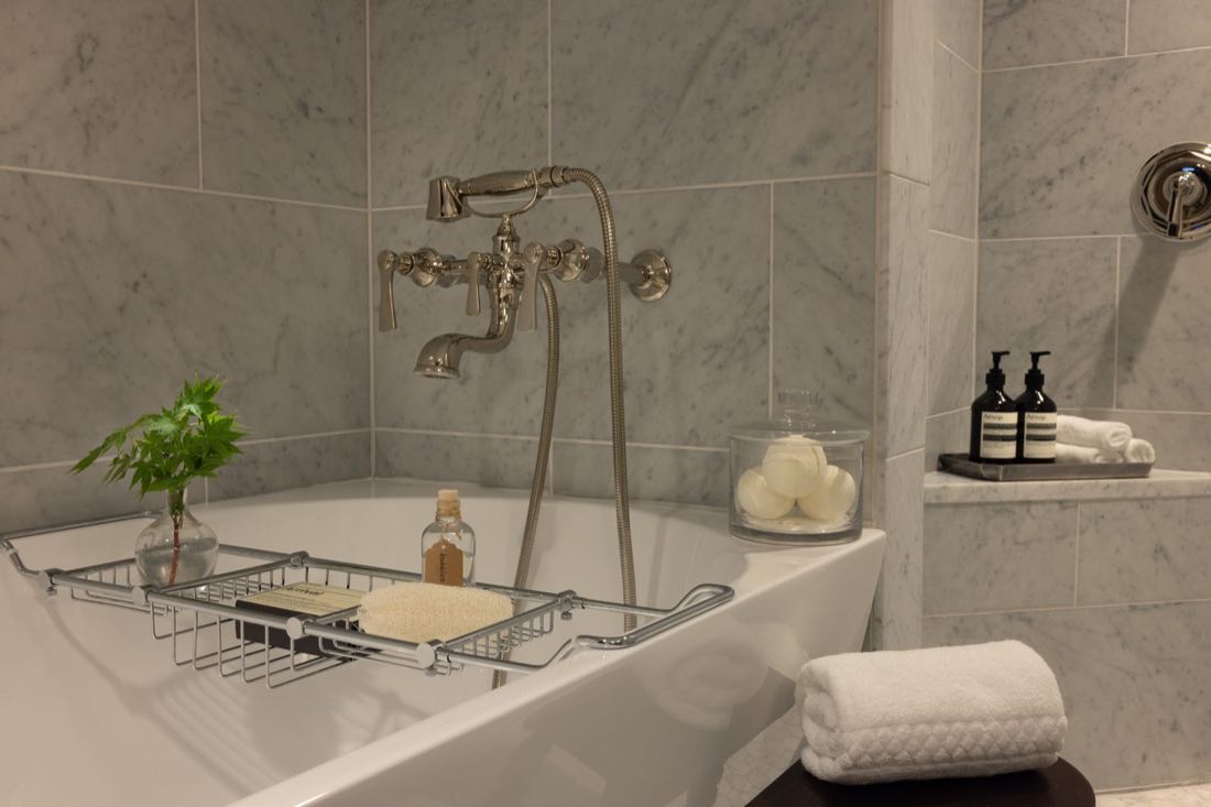 A bath detail in Room Five, the tub filler and a caddy of Aesop bottles.