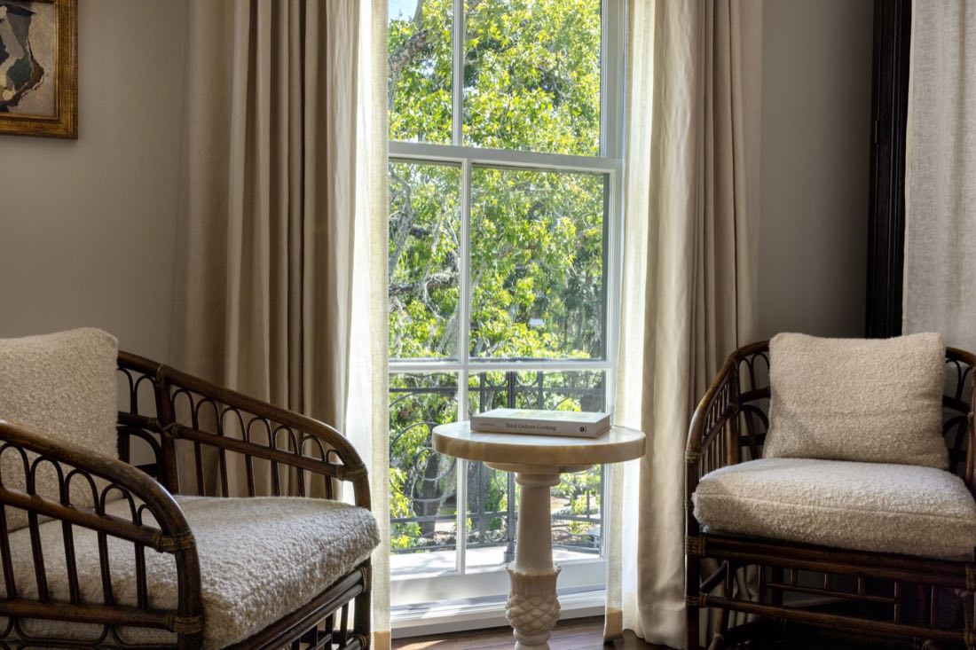The window seat in Room Twelve, two rattan chairs flanking a pedestal table.