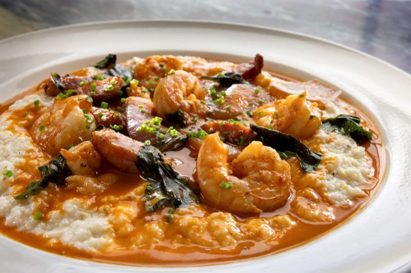 Lowcountry shrimp and grits with sausage, fried basil and tomato broth